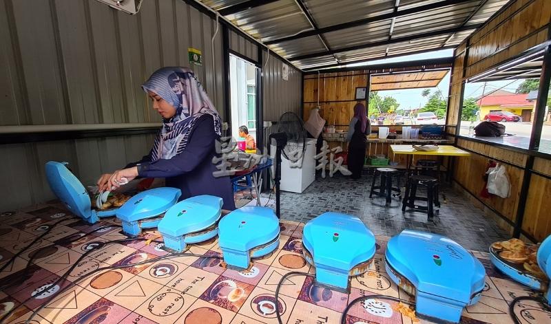 莫哈末沙米尔的小店一改炭烤的传统，以烤蛋糕机器制做akok，操作方便，也给人更卫生、干净的感觉。