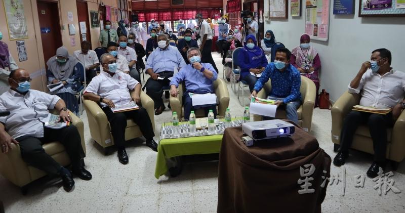 阿汉峇峇（坐者中）巡视林明诊所，并聆听关丹县卫生局官员汇报。