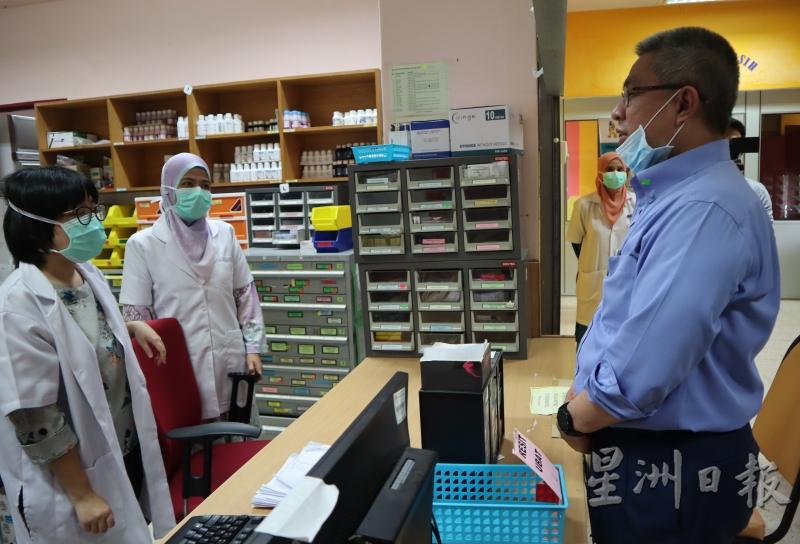 阿汉峇峇（右）向药剂房的医护人员了解问题。