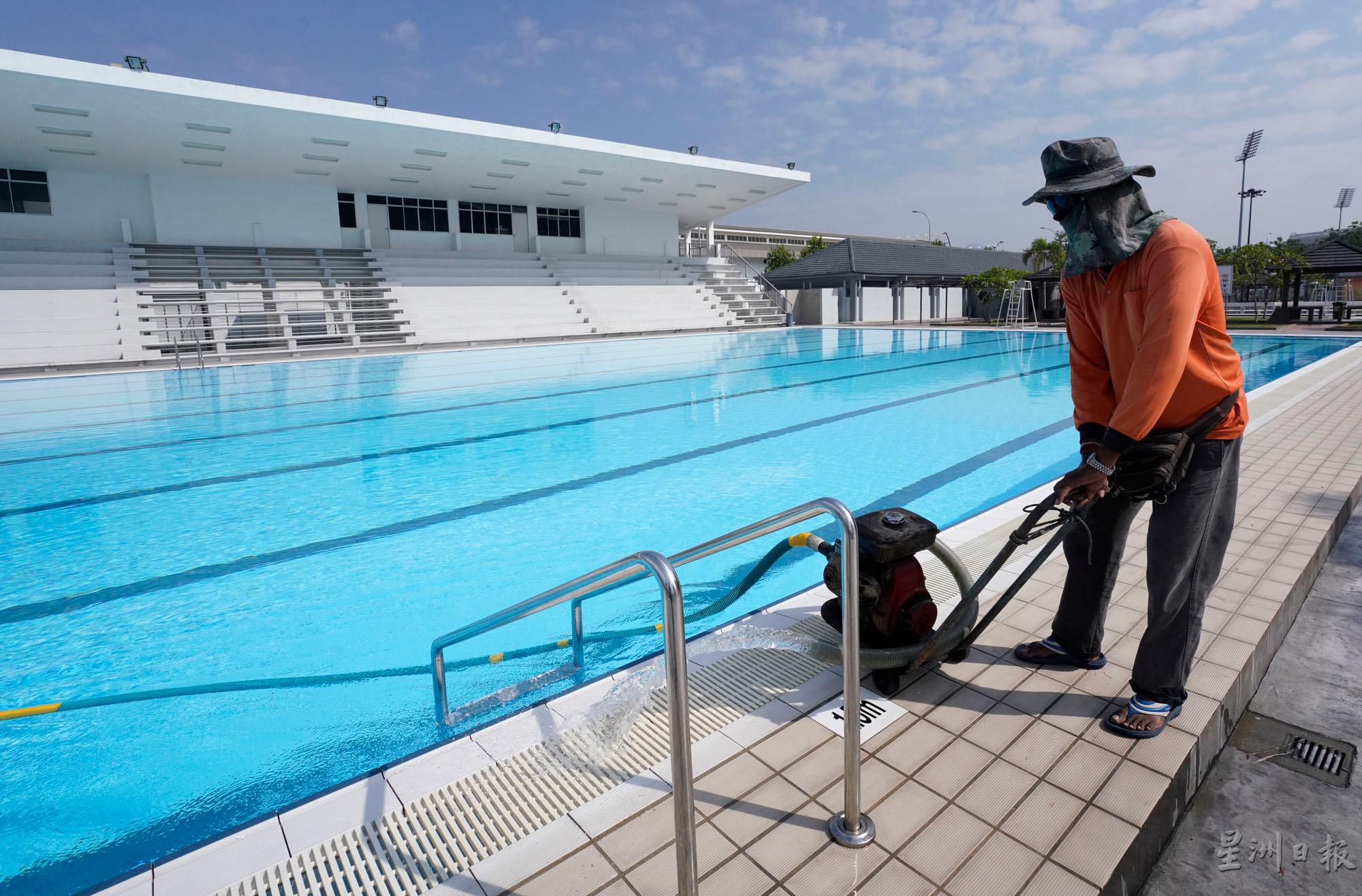 工作人员在泳池进行清理工作，为迎接7月1日泳池开放做好准备。