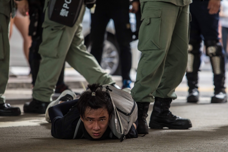 一名示威者遭防暴警制服在地上，随后被带走。（法新社照片）

