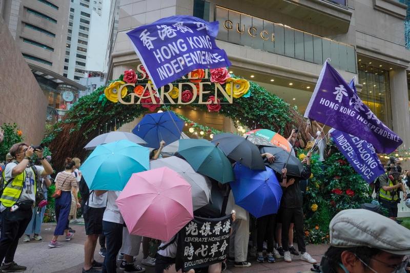 一些示威者在商场外筑起伞阵，并挥舞着“香港独立”和“光复香港，时代革命”的旗帜，公然挑战国安法。（美联社照片）