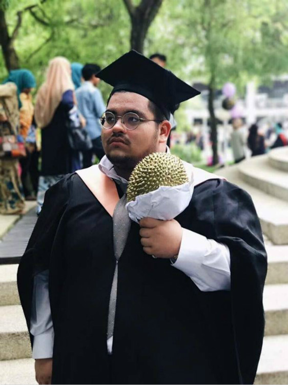 A university graduate holding a durian bouquet, a new trend in China which started two years ago. (photo extracted from online)