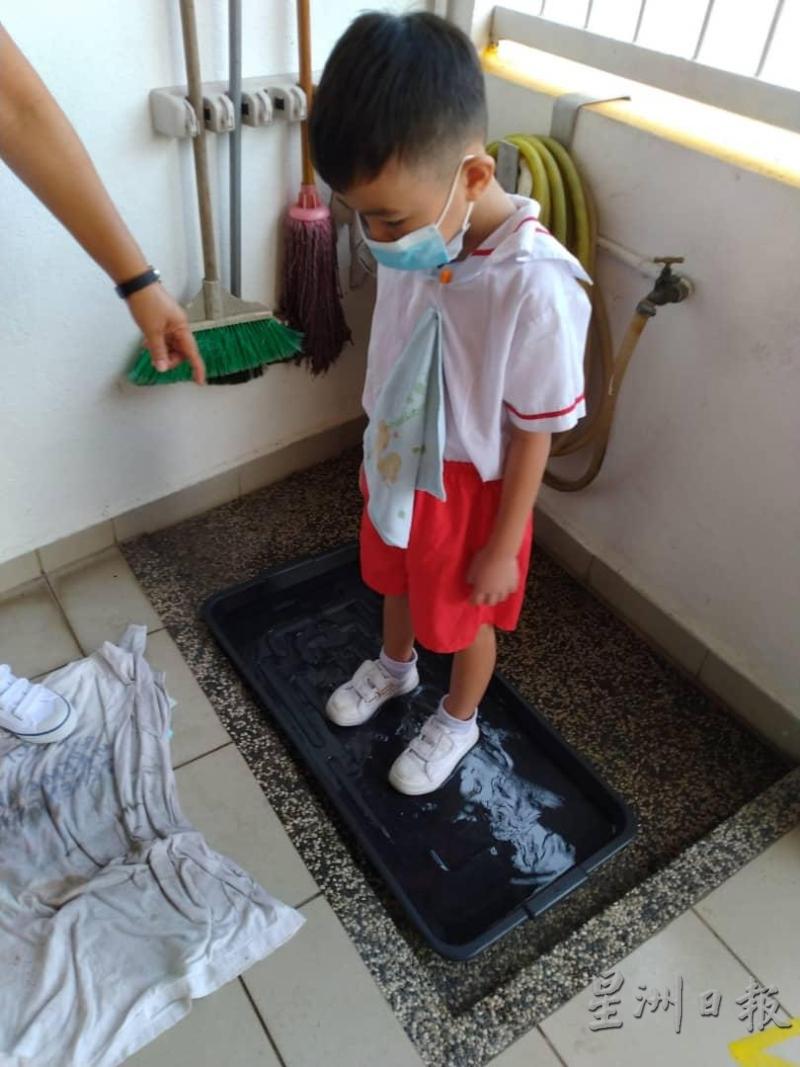 学生进入课室之前，先清理鞋底。