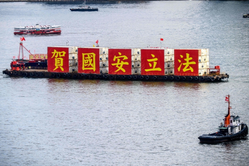 一艘船架著“贺国安立法”黄字红底5个大刊版在香港维多利亚港巡游。（法新社照片）