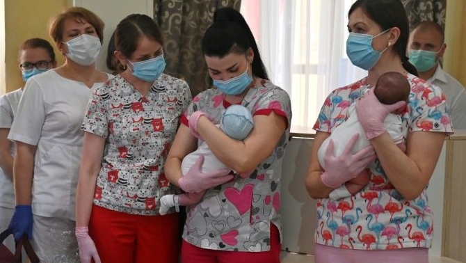 Nurses prepare to hand over babies to foreign couples at a Kiev hotel. AFP