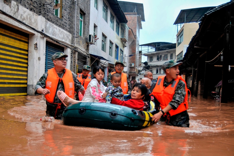 重庆日前暴雨引发洪灾，援救人员疏散居民。（法新社照片）