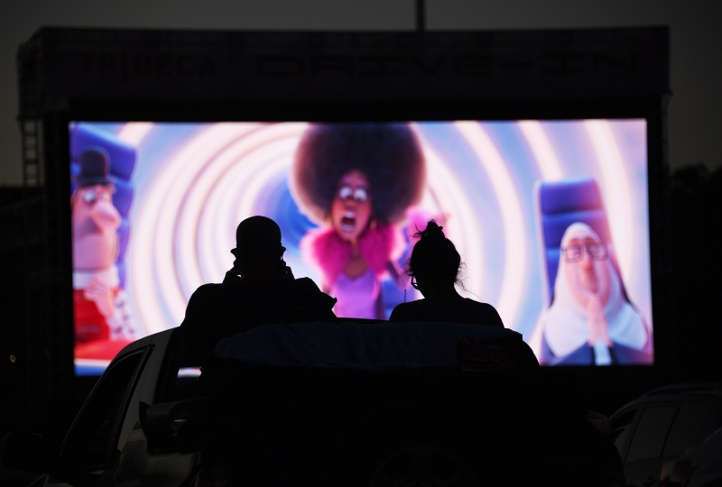 美国加州的汽车电影院举办了翠贝卡电影节，一对情侣在车顶观赏电影。