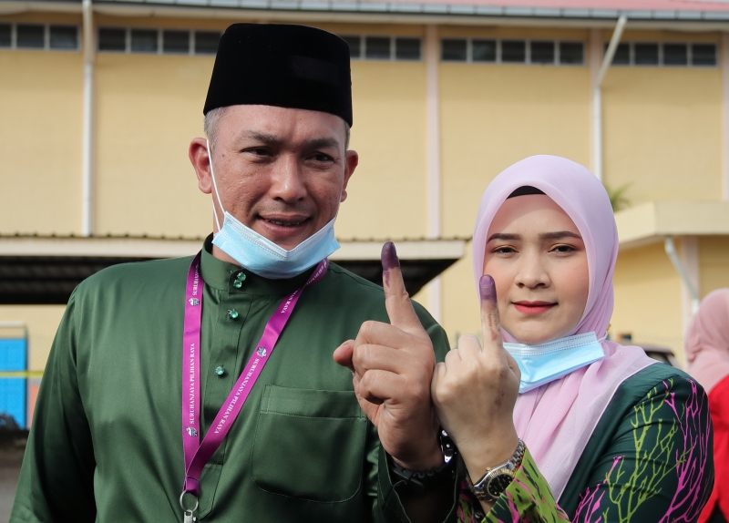 莫哈末沙林（左）与妻子诺希雅娜在完成投票后，一起展示涂上不褪色墨汁的手指。