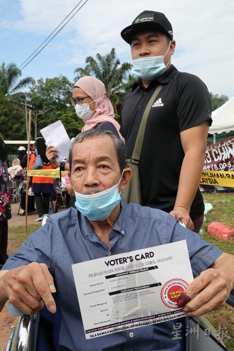 一名老选民向记者展示选举通知卡。