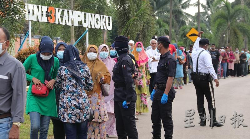 选民遵守SOP戴上口罩在投票站排队等候。