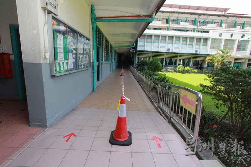 亚庇中华小学人行道被警戒线划分，地面贴上胶纸，为学生指示步行方向。