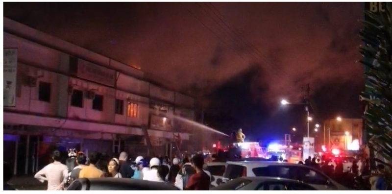 大和园巴刹对面两层楼店屋著火燃烧，消拯员正在射水灭火，现场吸引许多人围观。