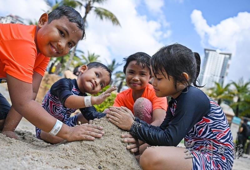 孩子开心的在沙滩上玩堆沙.