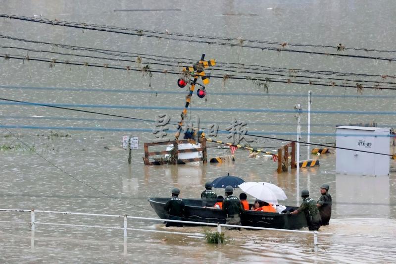 日本地面自卫队用小艇将灾民送往安全地点。（美联社照片）