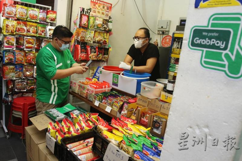 贩卖咖哩配料的张伟庆（右）已加入吉灵万山GrabMart线上巴刹计划，他认为可尝试开拓新市场。