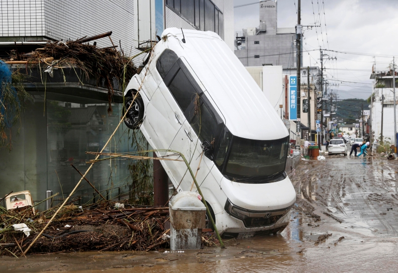 连休旅车都难抵洪水的威力，被冲到倾靠在房屋旁。 (美联社照片)