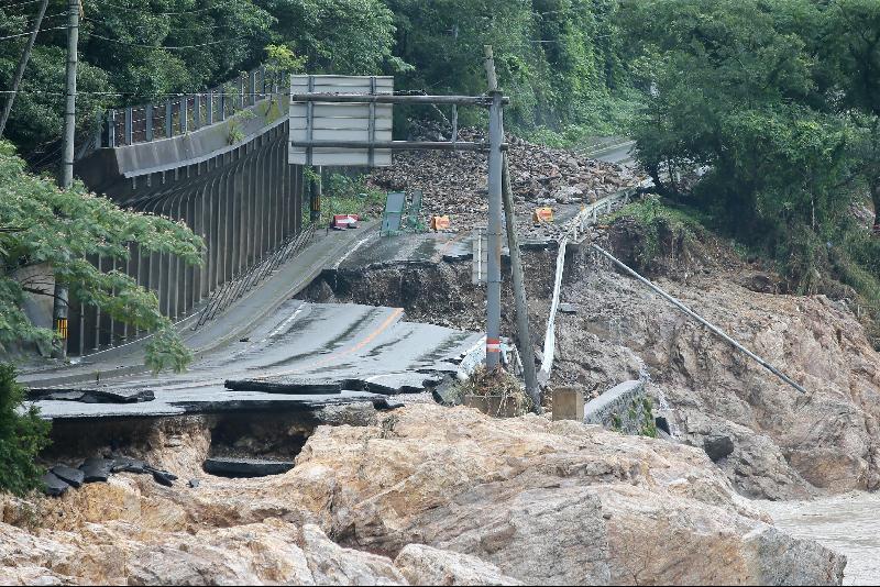 熊本县芦北町近球磨川的一条公路在暴雨洪水下被冲断。当地许多地区仍因桥断路裂，断水断电，呈孤立状态。（图：法新社）