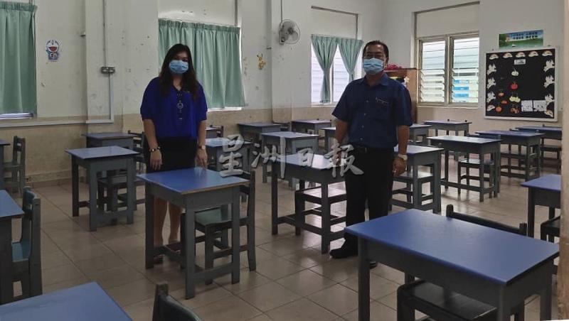 郑联友（右）与副校长邓业娣视察每一间课室，确保每张桌椅都保持距离。