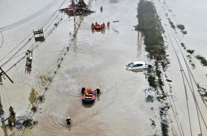 救护队利用船只救出受灾居民，但深洼和泥石流严重阻碍了救援的进度。 (美联社照片)