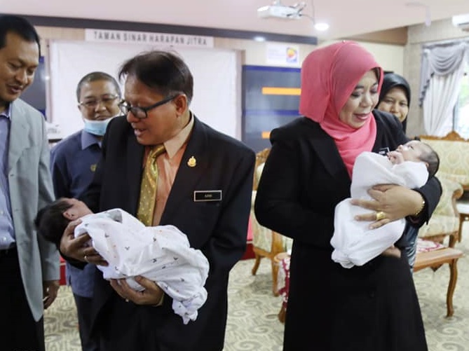 哈丽玛顿（右）和阿兹米手中各抱一名女婴，她们等候穆斯林符合资格者去领养。
