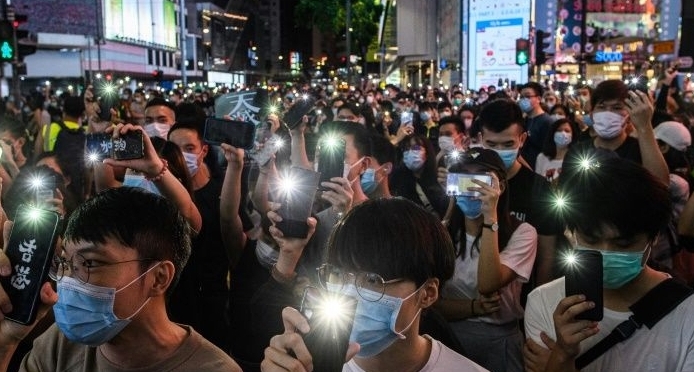 Hong Kong pro-democracy activists hold up their mobile phones during a rally. AFP
