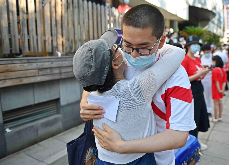 一名学生在进入考场应考前，拥抱他的母亲。