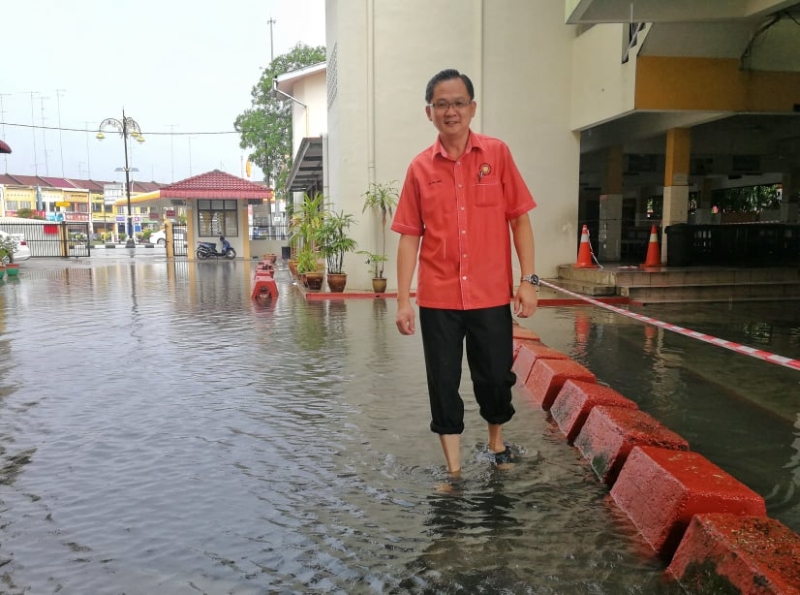 中化二A 校长郑伟明在校园内视察积水情况，他相信市区一带正在展开沟渠建造工程，又适逢农历五月十八河水涨潮所引发。