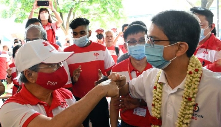 Fist bumps have replaced handshakes on the campaign trail as Singapore prepares for a general election. AFP