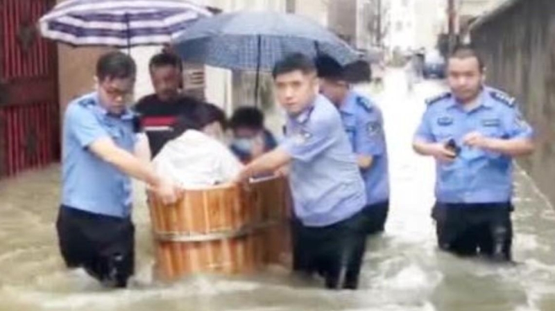 道路被水淹，安徽民警用澡盆运十余高考生去考场。(互联网照片)