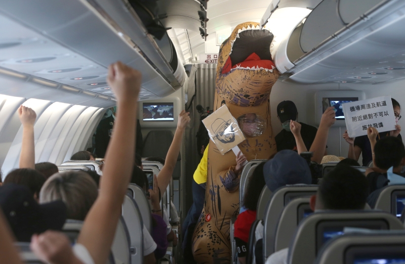 空姐穿上恐龙防疫装，与参与者玩机上有奖问答游戏。