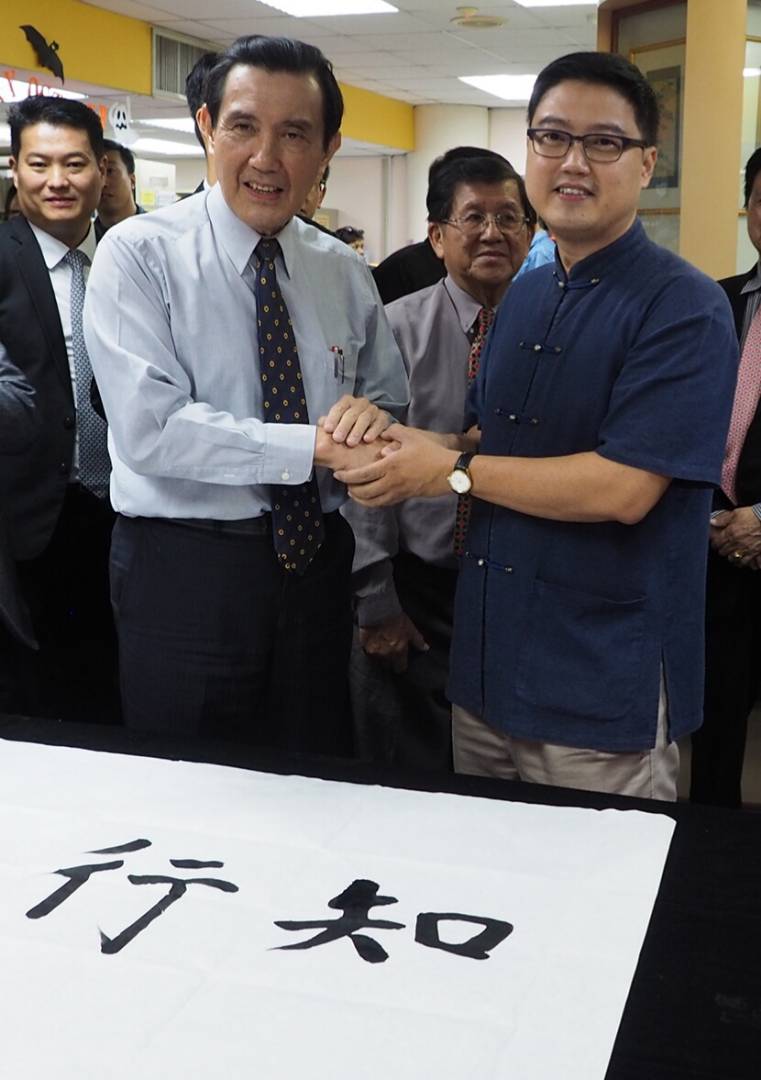 台湾前总统马英九（左）到访南方大学学院时，杨金荣（右）曾与他有一面之缘。当时，马英九还挥毫写下“知行合一”四个字赠给校方。