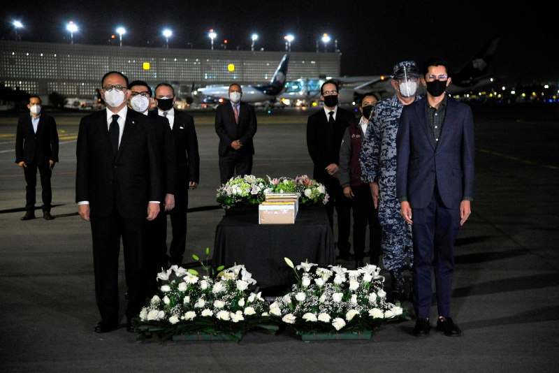 在墨西哥城機場舉辦的歸國儀式上，莊嚴肅穆的官員都戴上了口罩。（圖：法新社）