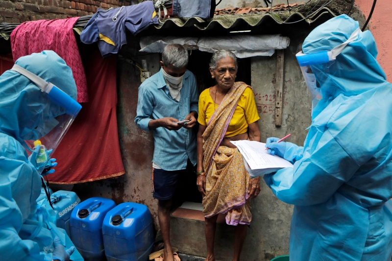 图为卫生人员周六在孟买贫民窟进行查访及检测居民。(美联社照片)