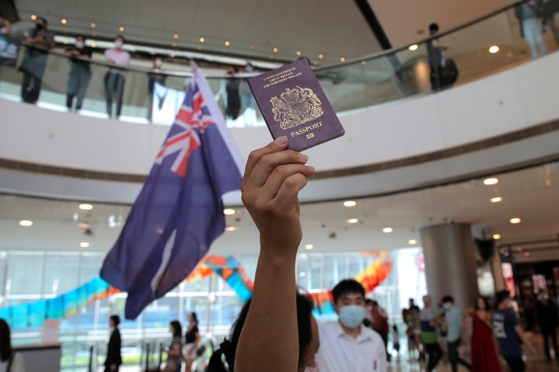 今年5月的抗议活动中，一名在商场内举起英国国民（海外）护照。（美联社照片）
