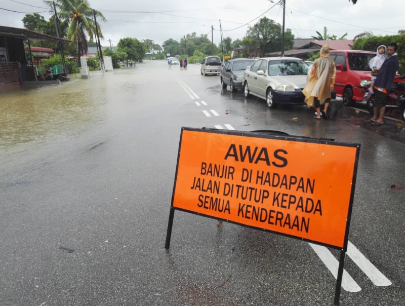 麻坡依斯迈路交通因发生水患而中断，当局已在该路段设立告示牌。