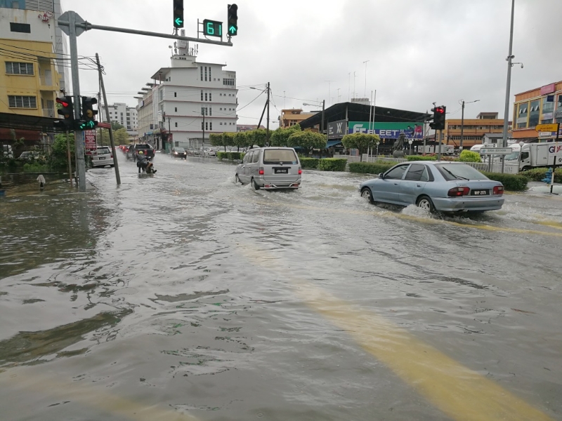 峇吉里路与文打烟及打石路交通灯处水位高涨，车辆无法转入打石路。