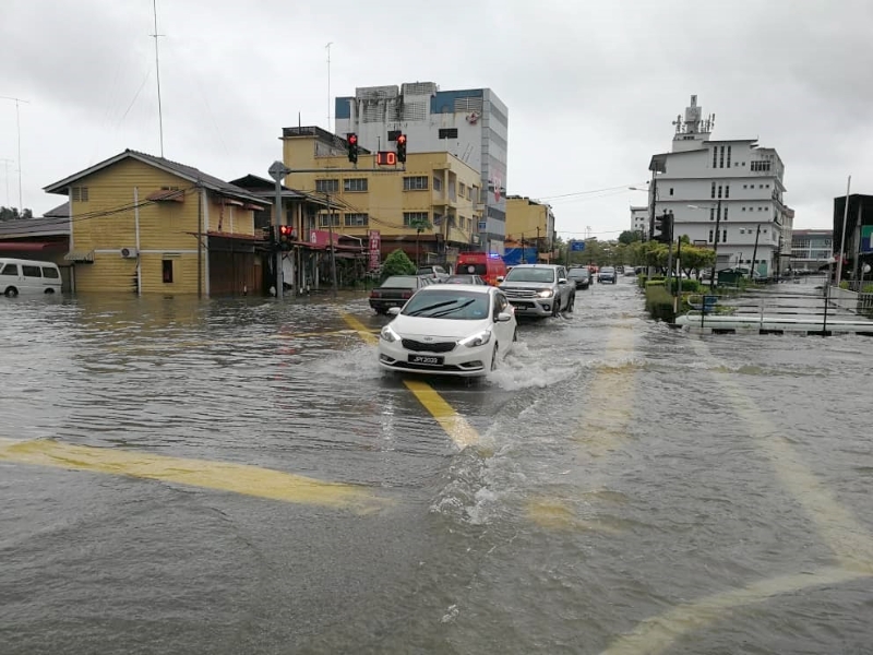 文打烟大沟水位高涨淹至路面，造成峇吉里路一英里处的交通灯路段水淹路面，车辆也不能左转入打石路。