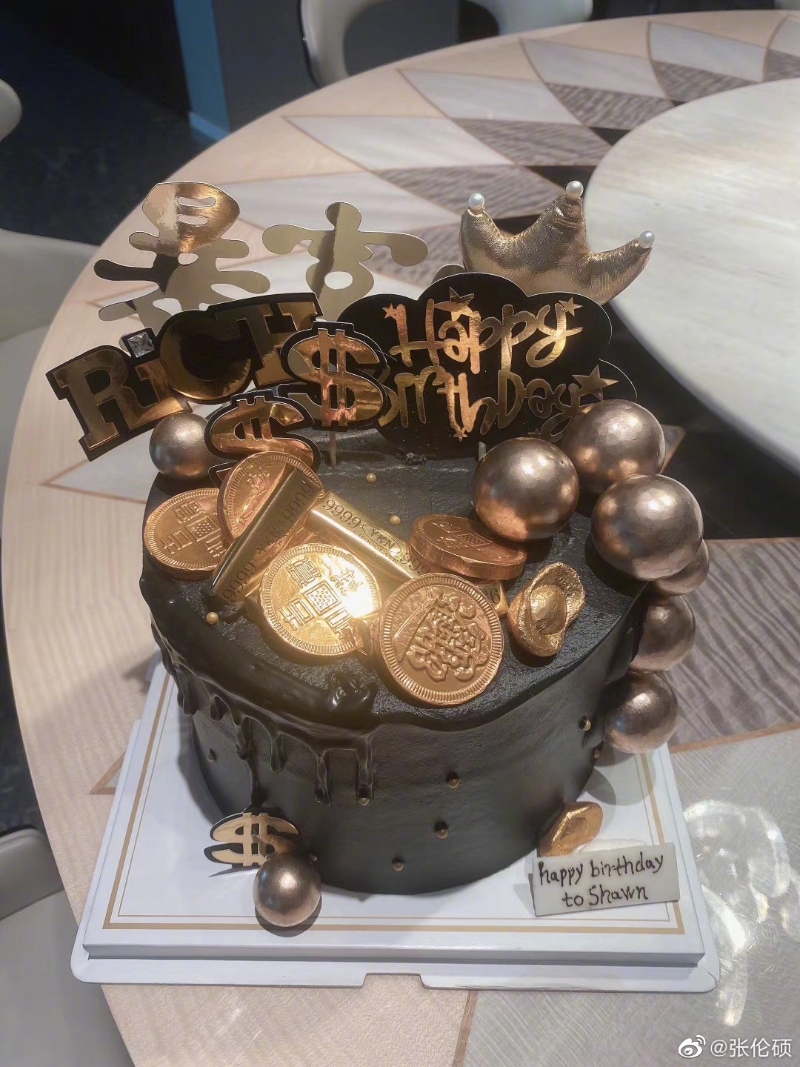 张伦硕的生日蛋糕以金色和啡色为主，上面放有金币装饰及致富字样，十分富贵。