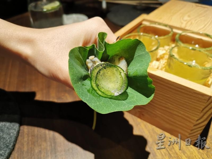 台北RAW餐厅的“海头皮／金山寺味噌／山葵”第二吃是把金莲叶置于虎口，再把配料放在上面，类似薄饼那样包起来吃。