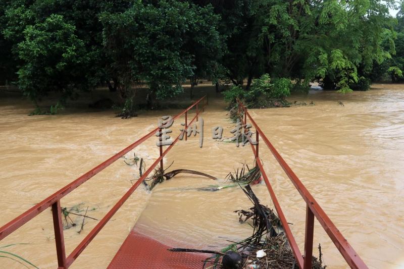 一夜豪雨，导致河水涌上甘榜本班的铁桥。