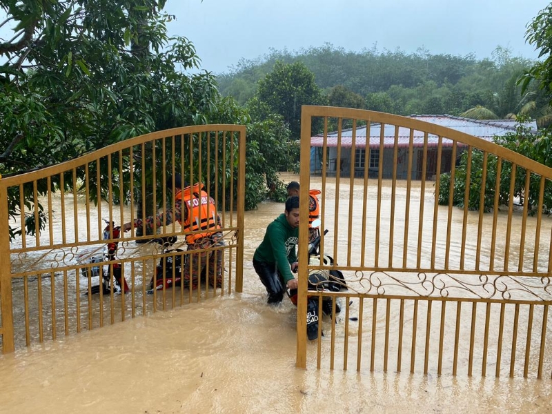 芙蓉甘榜本班发生严重水灾，消拯人员协助灾黎将交通工具移走。