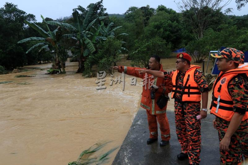 韩丹（左二）与众消拯员到场了解水灾情况。