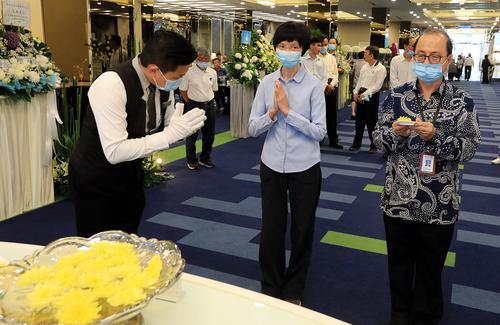 星洲日报基金会副主席萧依钊（中）和执行长刘昆昇（右）为陆老献上一朵黄菊，一心缅怀。