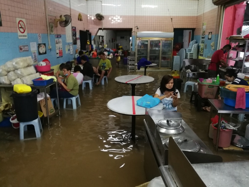 麻坡5天内二度闪电水患16地区沦陷。三马路华南咖啡店一片汪洋，摊位水贩坐着店内，顾客稀少，生意受影响。