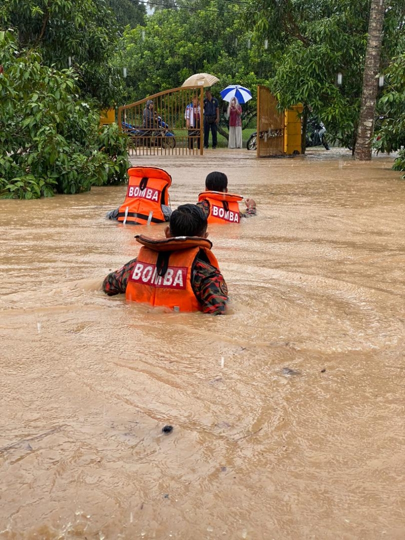 一雨成灾，芙蓉3区80户民宅淹水，水深达消拯员胸口。甘榜本班水位极深，消拯人员身穿救生衣涉水而过，走向“岸边”等待救援的灾黎。