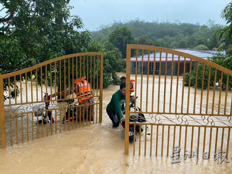 甘榜本班发生严重水灾，消拯人员协助灾黎将交通工具移走。