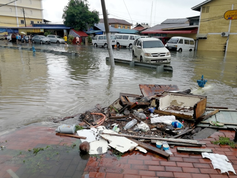 峇吉里路大路旁的大沟被水淹没，情况危险，垃圾也遗留在行人走道上。