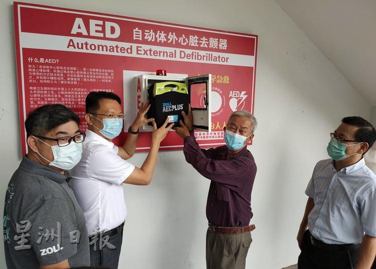 杨顺兴（左二起）和李受廷推介置于公民二校校园的AED。
