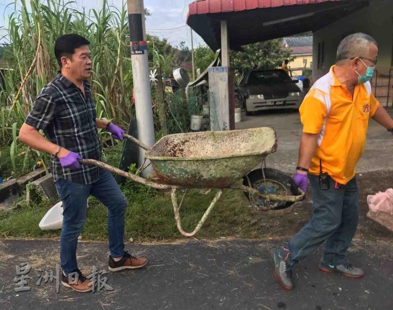 陈泽顺及自救会队员林华铨（右）一起帮忙清理杂物。